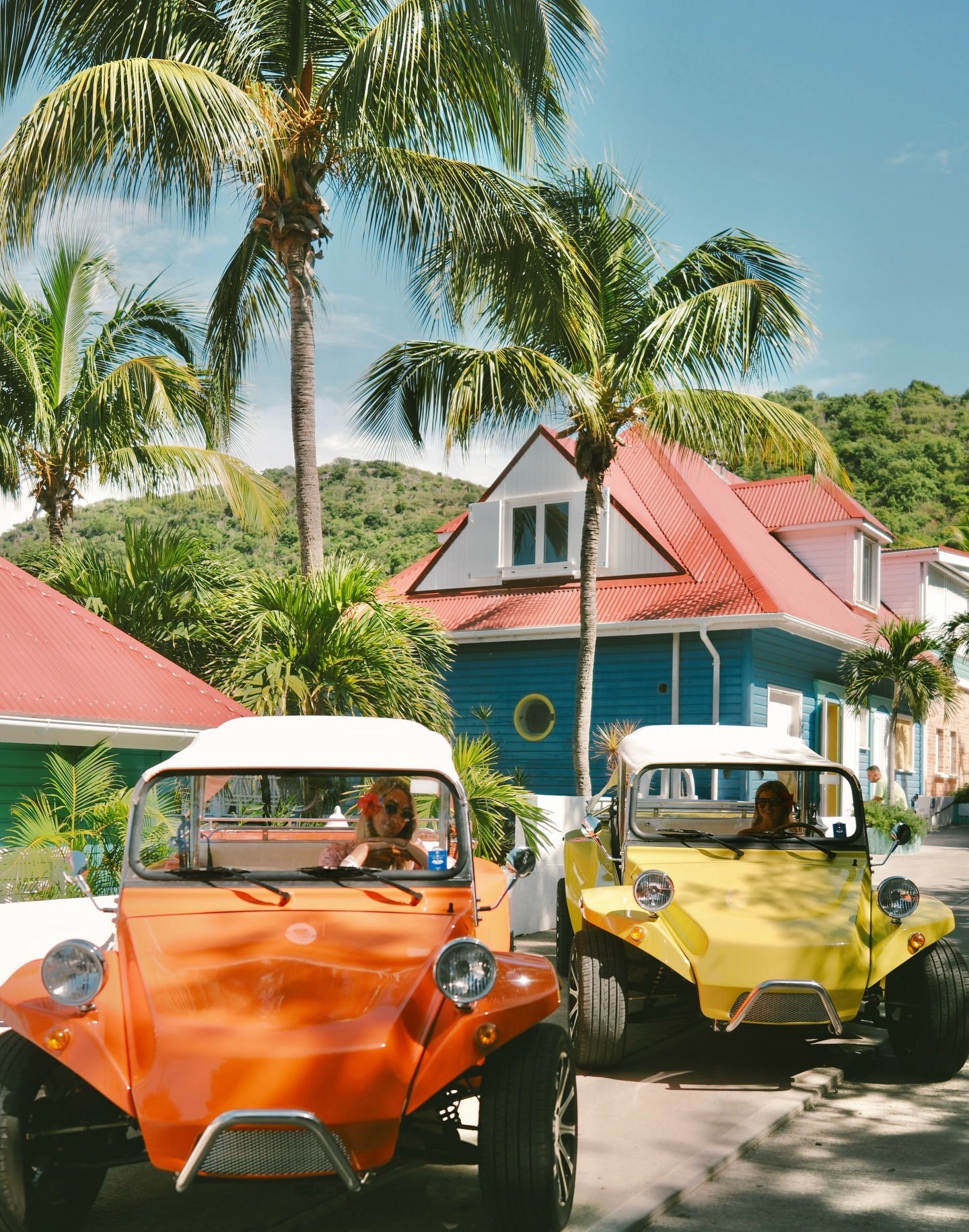 Orange and yellow Oreion Beach Buggies on a tropical island road