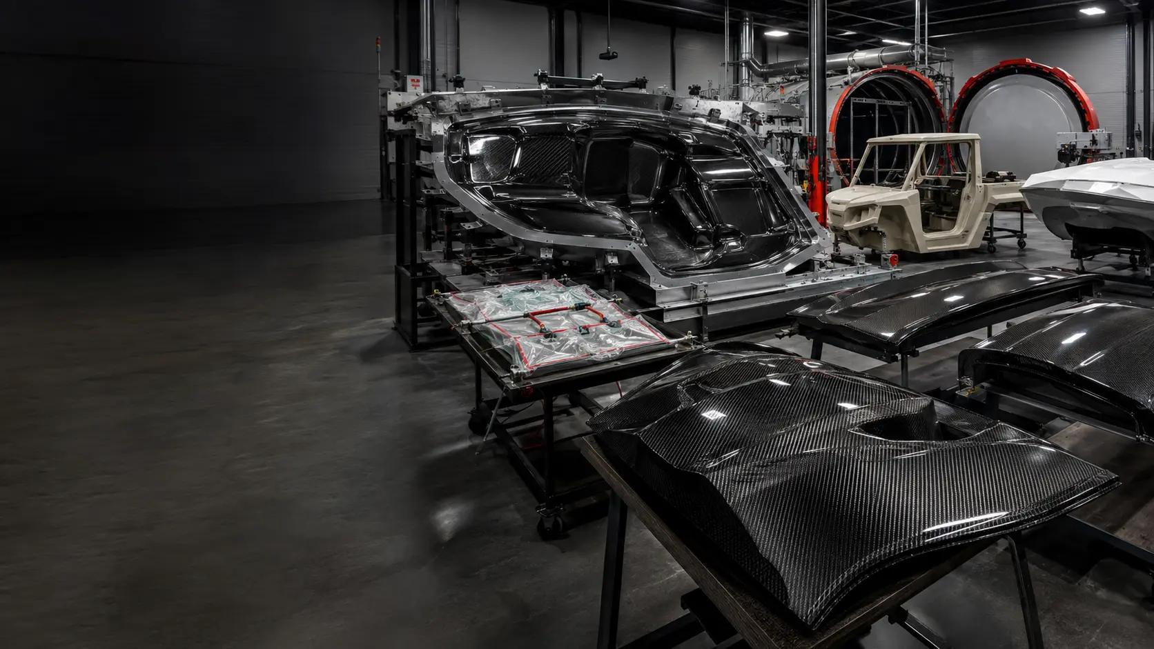 Carbon fiber and fiberglass composite manufacturing facility with vehicle molds and body panels